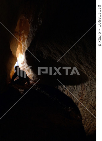 Spelunker exploring a cave 106813130