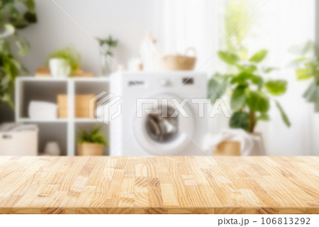 Empty wooden board with towels on blurred background of washing machine in home laundry. Place for product mounting and advertising Empty wooden board with towels on blurred background of washing machine in home laundry. Place for product mounting and advertising 106813292