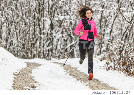 Girl runs on dirt road in winter Girl runs on dirt road in winter 106813324