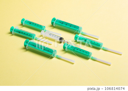 Top view of different syringes at yellow background. Medical injection concept with copy space 106814074