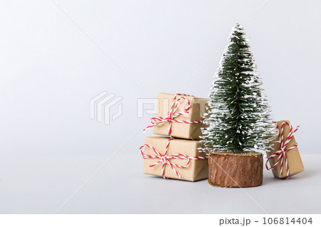 Christmas composition. Gifts, small tree, branches and craft DIY decorations on white background. New year concept. Christmas home decoration Flat lay, top view, copy space 106814404