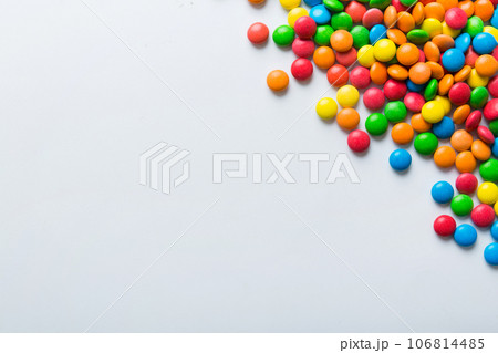 Mixed collection of colorful candy, on colored background. Flat lay, top view. frame of colorful chocolate coated candy Mixed collection of colorful candy, on colored background. Flat lay, top view. frame of colorful chocolate coated candy 106814485