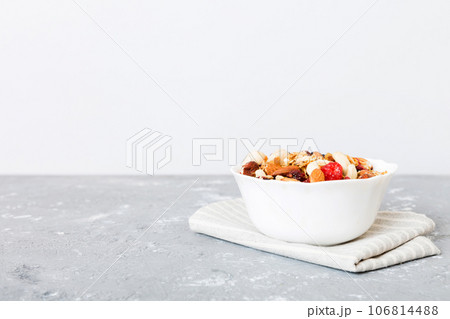 Cooking a wholesome breakfast. Granola with Various dried fruits and nuts in a bowl. The concept of a healthy dessert. Flat lay, top view with copy space 106814488