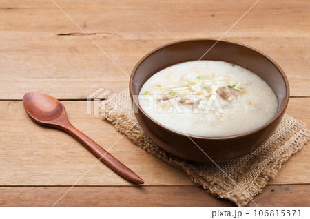 Traditional chinese porridge rice gruel in brown bowl with wooden spoon Traditional chinese porridge rice gruel in brown bowl with wooden spoon 106815371