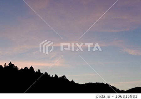 初秋の日没後の西空にたなびく茜雲 106815983