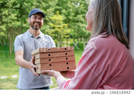 Deliveryman handing grocery or pizza to woman home. 106818992