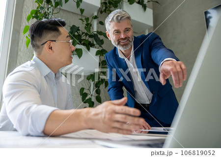 Architects in office using laptop and working on blueprint modeling new house together. 106819052