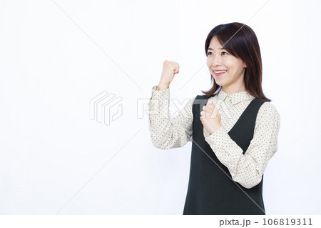 白い背景の前でガッツポーズをしている30代の女性 106819311