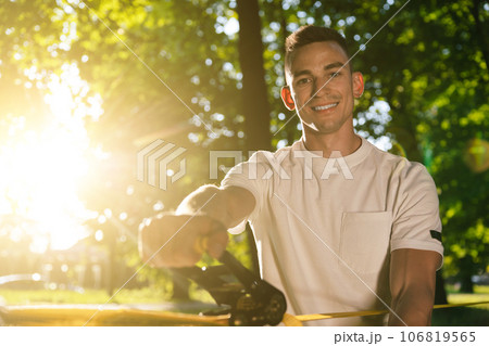 Young smiling man in the forest practising slacklining 106819565