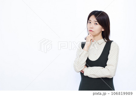 白い背景の前で悩んでいる30代の女性 106819989