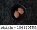 Organic brown raw eggs on black bowl. 3d illustration. 106820559