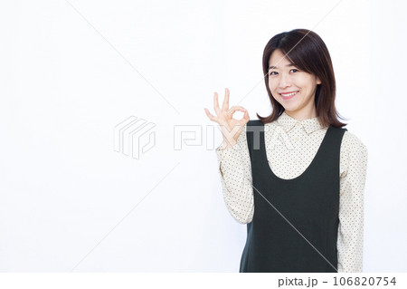 白い背景の前でOKサインをしている30代の女性 白い背景の前でOKサインをしている30代の女性 106820754