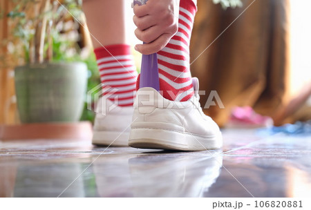 Person carries spoon with and puts on sports shoes closeup 106820881
