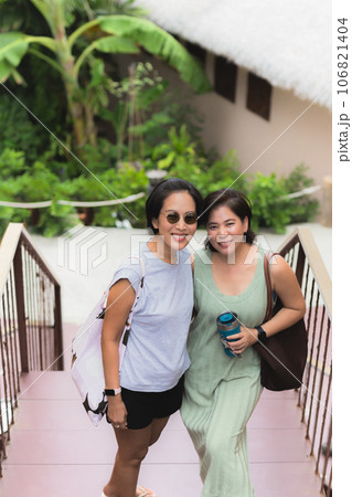 Two woman short hair standing together with happy smile looking at camera. 106821404