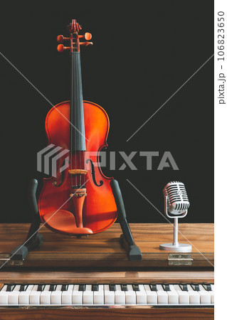 classical violin and retro condenser microphone on old piano. music background classical violin and retro condenser microphone on old piano. music background 106823650