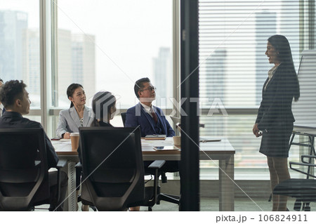 young asian businesswoman speaking to team of businesspeople in meeting in conference room young asian businesswoman speaking to team of businesspeople in meeting in conference room 106824911