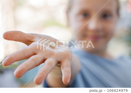 Fallen baby tooth in hand of happy little girl. The concept of hygiene of baby teeth Fallen baby tooth in hand of happy little girl. The concept of hygiene of baby teeth 106824979