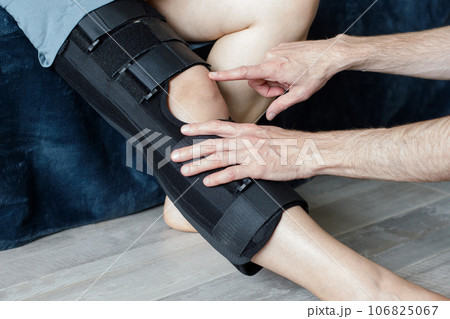 Therapist fitting a knee brace to patient leg Therapist fitting a knee brace to patient leg 106825067