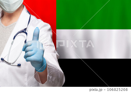 UAE doctor's hand showing thumb up positive gesture on flag of United Arab Emirates background 106825208