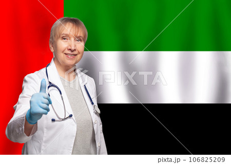 UAE smiling mature doctor woman holding stethoscope on flag of United Arab Emirates background 106825209