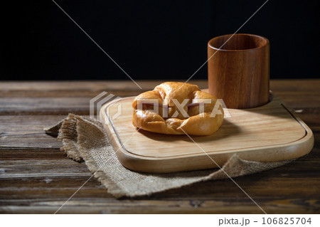Delicious Freshly Baked Croissants and cup on Rustic Wooden Platter Delicious Freshly Baked Croissants and cup on Rustic Wooden Platter 106825704