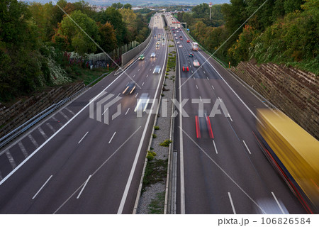 Long exposure photo of traffic with blurred traces from cars, top view. road, cars, blurred traffic, evening, top view. Highway at evening, blue hour illuminated by the traffic of cars 106826584
