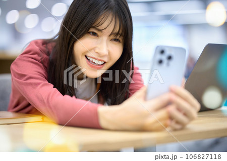 コワーキングスペースでスマホを操作する女性 106827118