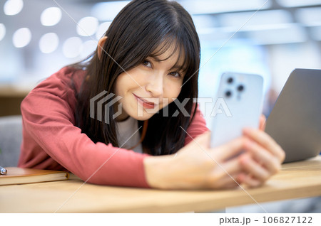 コワーキングスペースでスマホを操作する女性 コワーキングスペースでスマホを操作する女性 106827122