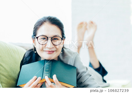 ソファーで読書するシニア女性のポートレート 106827239