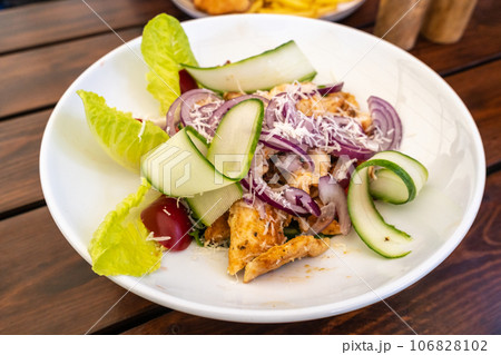 Caesar Salad Closeup, Grilled Chicken Salat with Parmesan Cheese, Greens, Dressing and Cucumbers Caesar Salad Closeup, Grilled Chicken Salat with Parmesan Cheese, Greens, Dressing and Cucumbers 106828102