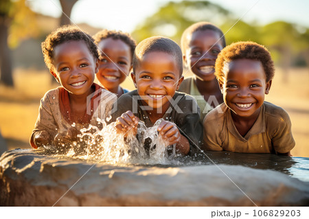African children enjoy clean water and stretches out his hands to tank with fountain of clean water. 106829203
