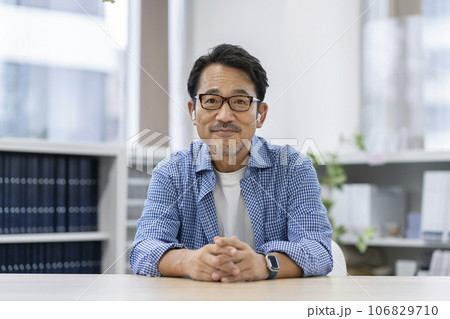 カメラ目線のイヤホンをした50代の男性　 106829710