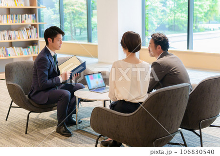 夫婦に説明をするビジネスマン 106830540