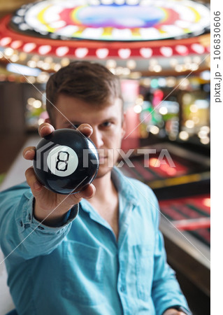 Man shows ball with number to camera. Lucky number or winning lottery. Numerology and divination 106830606