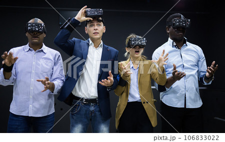 Surprised friends playing video games using virtual reality glasses 106833022