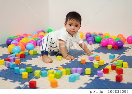 infant baby playing wooden block toy in playpen infant baby playing wooden block toy in playpen 106835092