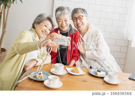 カフェで写真を撮るシニア女性達 カフェで写真を撮るシニア女性達 106836568