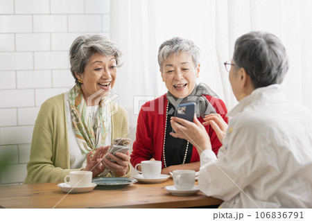 カフェでお茶をするシニア仲間・スマホを見るシニアの女性たち 106836791