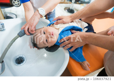 初めての美容室でシャンプー台に乗って洗ってもらう生後8か月の男の子の赤ちゃん 初めての美容室でシャンプー台に乗って洗ってもらう生後8か月の男の子の赤ちゃん 106837921