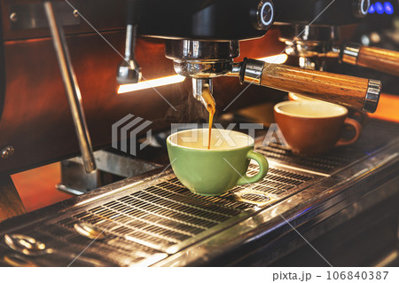 Espresso pouring from coffee machine 106840387