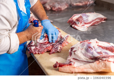 Butcher cutting fresh meat 106840396