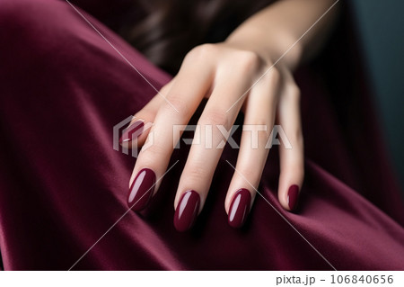 Glamour woman hand with deep berry and plum nail polish on fingernails. Nail manicure with gel polish at luxury beauty salon. Nail art and design. Female hand model. French manicure. Generative AI. 106840656