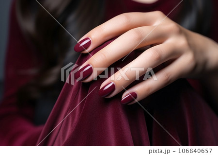 Glamour woman hand with deep berry and plum nail polish on fingernails. Nail manicure with gel polish at luxury beauty salon. Nail art and design. Female hand model. French manicure. Generative AI. 106840657