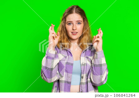 Woman crossed fingers looking at camera ask for good luck news, wishing good exam results, play game 106841264