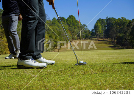 Golfers are putting golf in the evening golf course golf backglound. 106843282