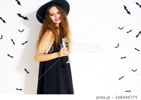 happy young woman in black witch halloween costume on party over white background with bats. happy young woman in black witch halloween costume on party over white background with bats. 106846775