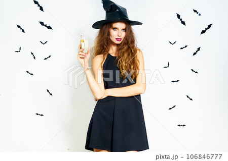 happy young woman in black witch halloween costume on party over white background with bats. happy young woman in black witch halloween costume on party over white background with bats. 106846777