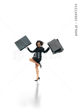 Black friday concept. Full lenth portrait of young woman wearing officilly outfit raising hands with huge bags with prchases. Shopaholik Black friday concept. Full lenth portrait of young woman wearing officilly outfit raising hands with huge bags with prchases. Shopaholik 106847254