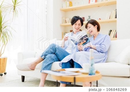 一緒に雑誌を見るカップル 106848269