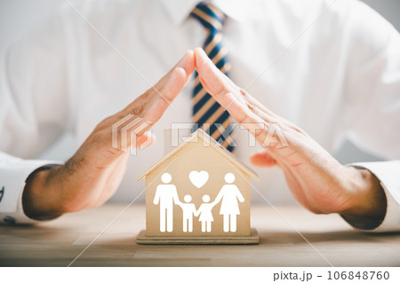 Conveying family insurance and care ideals. Businessman protective gesture with family silhouette. Icons for family, life, health, and house insurance. Capturing insurance concept. 106848760